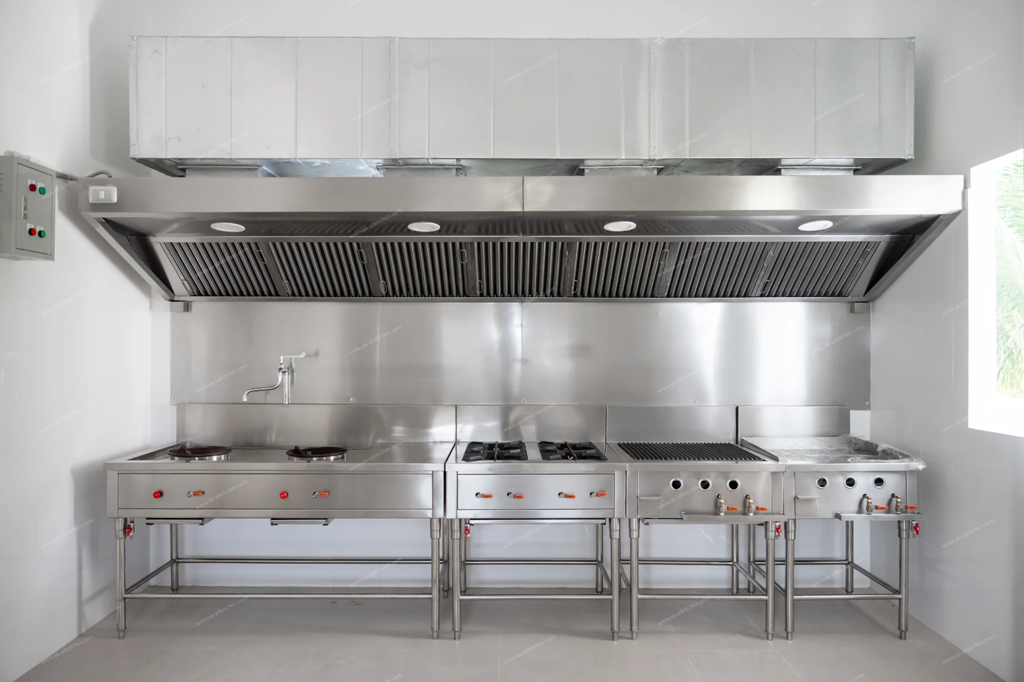 Installed stainless steel cooking line beneath an extraction canopy